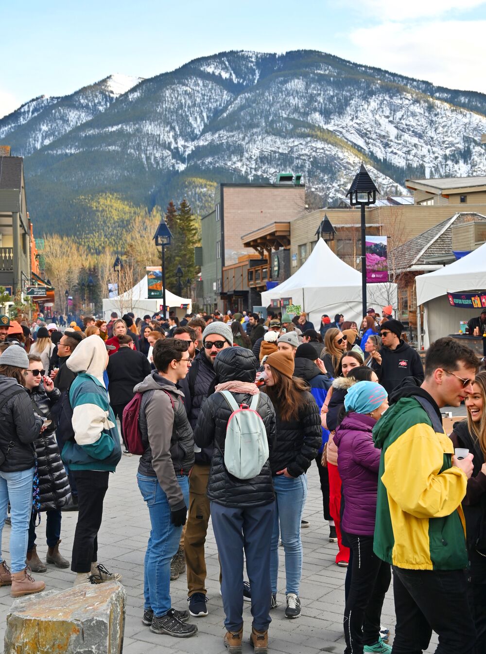 People mill about at the Bear Street outdoor festival during Made with Love - Banff Food & Cocktail Festival